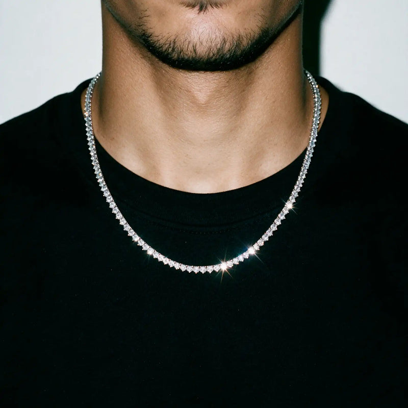 Silver 4MM tennis chain worn over a black tee, chest and chin in frame