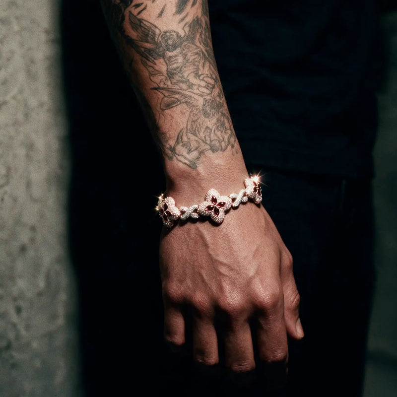 Rose gold 20MM quatrefoil bracelet set with red stones worn on a tattooed wrist